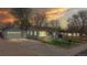 Charming single-Gathering home with a detached garage and green lawn at sunset at 415 S Parfet St, Lakewood, CO 80226