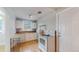 Kitchen featuring white cabinets, tile backsplash, and updated appliances at 415 S Parfet St, Lakewood, CO 80226