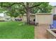 Backyard with lush lawn, patio seating, a barbecue grill, storage shed, and beautiful landscaping at 10527 Pierson Cir, Westminster, CO 80021