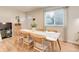 Dining room featuring a long wood table set for six, a large window, and a view of the front door at 10527 Pierson Cir, Westminster, CO 80021