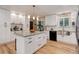 Spacious kitchen features white cabinets, a large island, stainless steel sink, and modern appliances at 10527 Pierson Cir, Westminster, CO 80021