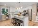 Bright kitchen featuring white cabinets, stainless steel appliances, a large island with seating, and wood flooring at 10527 Pierson Cir, Westminster, CO 80021
