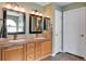 Bathroom featuring double sinks, vanity, large mirrors, and plenty of counter space at 11951 Singing Winds St, Parker, CO 80138