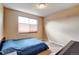 Bright bedroom featuring carpet flooring, neutral walls, window and double bed with blue quilt at 11951 Singing Winds St, Parker, CO 80138