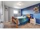 Cozy bedroom with gray and blue walls, carpet flooring, and wooden bed frame at 11951 Singing Winds St, Parker, CO 80138