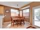 Cozy dining room featuring a bay window, wood table and chairs, and direct access to the backyard at 11951 Singing Winds St, Parker, CO 80138