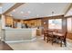 Spacious kitchen with light wood cabinets, a breakfast bar, and an adjacent dining area at 11951 Singing Winds St, Parker, CO 80138