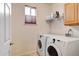 Functional laundry room with a washer, dryer, storage shelves and a window for natural light at 11951 Singing Winds St, Parker, CO 80138