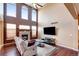 Spacious living room featuring large windows, a fireplace, and hardwood floors at 11951 Singing Winds St, Parker, CO 80138