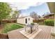 A backyard featuring a patio with a dining table, detached garage, and a green lawn at 250 S Ogden St, Denver, CO 80209