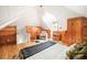 Charming bedroom featuring wood paneled walls, vaulted ceiling, and a cozy chair near the bright window at 250 S Ogden St, Denver, CO 80209
