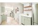 Open-concept kitchen and dining area features stone floors and light-green cabinetry with gold fixtures at 250 S Ogden St, Denver, CO 80209