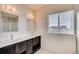 Double vanity bathroom with dark brown cabinets and window at 11099 Pastel Pt, Parker, CO 80134