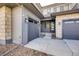 Two-car garage and entryway with stone accents and lighting at 11099 Pastel Pt, Parker, CO 80134