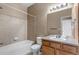 Bright bathroom features a tub with tiled surround and vanity with sink and a large mirror at 9387 Ashbury Cir # 203, Parker, CO 80134