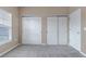 Neutral bedroom featuring a bright window with blinds and two closets with sliding doors at 9387 Ashbury Cir # 203, Parker, CO 80134