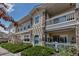 Charming exterior view of the home with stone accents, a private balcony, and lush landscaping at 9387 Ashbury Cir # 203, Parker, CO 80134