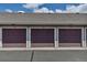 Exterior view of a row of attached garages, each with dark brown doors and unit numbers above at 9387 Ashbury Cir # 203, Parker, CO 80134
