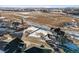 Aerial view of a snow-covered vacant lot next to modern home in a residential area with utility truck and great open space views at 945 Saint Andrews Ln, Louisville, CO 80027