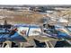 Aerial view of a snow-covered vacant lot next to modern home in a residential area and open space views at 945 Saint Andrews Ln, Louisville, CO 80027