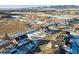 Aerial view of a home under construction in a snowy neighborhood with mountain views in the background at 945 Saint Andrews Ln, Louisville, CO 80027
