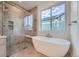 Modern bathroom with a soaking tub next to a glass shower with a bench and a large window at 945 Saint Andrews Ln, Louisville, CO 80027