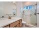 Modern bathroom with a glass enclosed shower, and a marble countertop vanity with bronze fixtures at 945 Saint Andrews Ln, Louisville, CO 80027