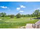 Scenic golf course view featuring manicured greens, mature trees, and a clear blue sky at 945 Saint Andrews Ln, Louisville, CO 80027