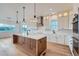 Open kitchen featuring a large island, pendant lighting, stainless steel appliances, and light wood floors at 945 Saint Andrews Ln, Louisville, CO 80027