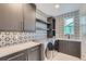 This is a modern laundry room featuring a washer and dryer, as well as custom cabinets, countertops and tile backsplash at 945 Saint Andrews Ln, Louisville, CO 80027