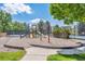 A community playground with slides, climbing structures, and a tennis court is surrounded by trees at 945 Saint Andrews Ln, Louisville, CO 80027