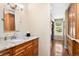 Bathroom with wood cabinets, granite counters, and natural light, next to a hallway with built-in cabinets at 1555 Genesee Ridge Rd, Golden, CO 80401