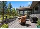 Outdoor deck with comfortable seating, a grill, and views of the surrounding trees and greenery at 1555 Genesee Ridge Rd, Golden, CO 80401