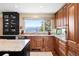 Well-lit kitchen with dark stained wood cabinets and a granite countertop with mountain view at 1555 Genesee Ridge Rd, Golden, CO 80401