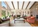 Comfortable living room with wood-burning fireplace, vaulted ceilings, exposed beams, and ample natural light at 1555 Genesee Ridge Rd, Golden, CO 80401