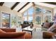 Spacious living room with vaulted ceilings, exposed beams, large windows and sliding glass doors to a deck at 1555 Genesee Ridge Rd, Golden, CO 80401