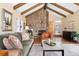Inviting living room boasts stone fireplace, beamed ceilings, and an open floor plan at 1555 Genesee Ridge Rd, Golden, CO 80401