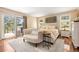 Bright main bedroom with hardwood floors, a seating area, and a walkout balcony showcasing scenic outdoor views at 1555 Genesee Ridge Rd, Golden, CO 80401