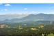 Stunning mountain view showcasing lush green forests and snow-capped peaks on the horizon at 1555 Genesee Ridge Rd, Golden, CO 80401
