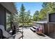 Relaxing deck with a hot tub, outdoor seating, and picturesque views of the surrounding trees and landscape at 1555 Genesee Ridge Rd, Golden, CO 80401