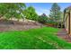 Expansive backyard featuring lush green grass, a terraced garden, and a charming covered patio for outdoor enjoyment at 9939 E Aberdeen Ave, Englewood, CO 80111