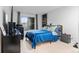 This bedroom has a large window with curtains and a blue bed with a geometric throw pillow at 9939 E Aberdeen Ave, Englewood, CO 80111