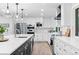 Spacious kitchen with stainless steel appliances, white cabinets, and a large island with quartz countertops at 9939 E Aberdeen Ave, Englewood, CO 80111