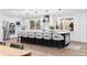 Modern kitchen featuring white cabinets, stainless appliances, and an expansive island with pendant lighting at 9939 E Aberdeen Ave, Englewood, CO 80111