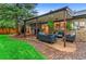 This cozy covered patio includes comfortable seating, hanging plants, and easy access to the indoors at 9939 E Aberdeen Ave, Englewood, CO 80111