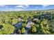 Aerial view of home in a neighborhood of lush green trees with blue skies and a mountain view at 14150 Foothill Ln, Golden, CO 80401