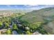 Scenic aerial view of hillside homes nestled among lush greenery and distant mountain range at 14150 Foothill Ln, Golden, CO 80401