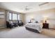 Bedroom with a queen bed, large window, neutral carpeting, and side tables with lamps at 14150 Foothill Ln, Golden, CO 80401