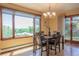 Bright dining room with wood floors, large windows offering scenic views, and access to outdoor space at 14150 Foothill Ln, Golden, CO 80401