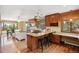 Bright kitchen featuring an island with seating, granite countertops, wood cabinets and floors at 14150 Foothill Ln, Golden, CO 80401